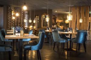 HelvoirtDe Guldenberg 's-Hertogenbosch Helvoirt的餐厅设有木桌和蓝色椅子