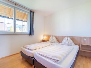 隆高地区圣玛格丽滕Apartment in St Margarethen with balcony的一间卧室设有两张床和窗户。