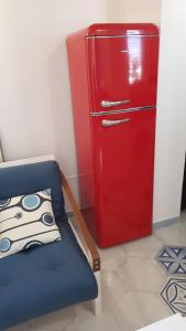 伊斯基亚casetta的蓝色椅子的房间里装有红色冰箱