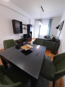 阿然德洛维克Apartman Green wood的客厅配有黑桌和绿色椅子