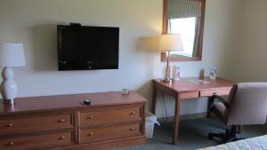 加尔维斯敦水上公园客栈的酒店客房设有一张桌子和一台墙上的电视