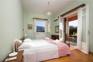 科孚镇Villa Dorina by Corfuescapes的卧室配有一张白色的大床和一张桌子