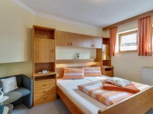 费斯Lively flat near a ski resort in Fiss的一间小卧室,配有一张床和一把椅子