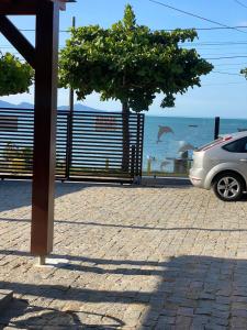 贝卢港Apartamento Frente Mar na Baía de Porto Belo的停在海边的带围栏的汽车