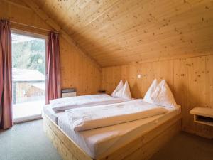 穆尔河畔施塔德尔Chalet near the Kreischberg ski area的木制客房的一张床位,设有窗户