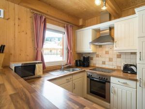 穆尔河畔施塔德尔Chalet near the Kreischberg ski area的厨房配有白色橱柜、水槽和窗户。