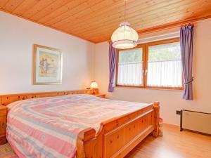 伊塞尔斯堡Quaint Chalet with Garden Terrace Fireplace Play Equipment的一间卧室设有一张大床和木制天花板。