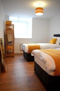 利物浦Olu Apartments Belem Tower Sefton Park的一间卧室设有两张床和窗户。