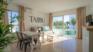 普拉亚登博萨Tabbu ibiza apartments的客厅配有桌椅和沙发