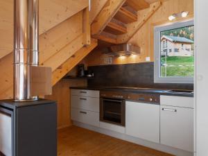 上陶恩Chalet in Hohentauern in the ski area的厨房配有白色橱柜和窗户。