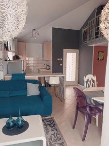 乌马格Apartment Gaia的一间带蓝色沙发的客厅和一间厨房