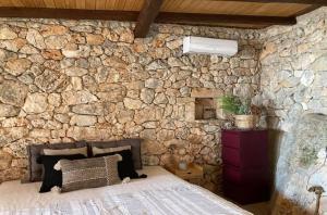 阿尔戈斯托利翁Kamaroules Sea Front的客房内的石墙和床