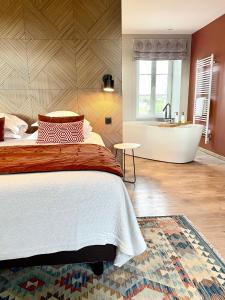 RévilleLa Maison Gervaiserie & Spa的一间卧室配有一张床和浴缸