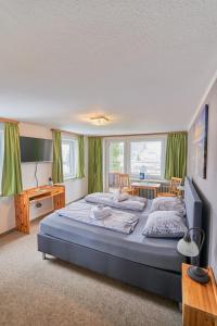 上罗伊特克朗乡村酒店的一间卧室配有一张带绿色窗帘的大床