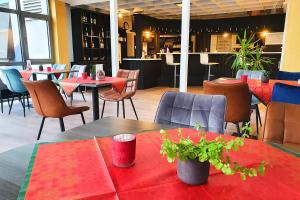 肯钦根Sport Hotel Kenzingen的餐厅配有桌椅和红色桌布