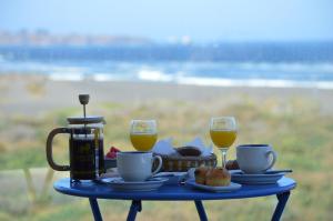 皮奇勒姆Esfera Pichilemu - Lodge的一张带食物托盘的蓝色桌子和两杯橙汁