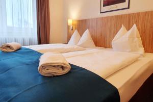 肯钦根Sport Hotel Kenzingen的酒店客房,配有两张带毛巾的床