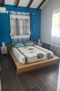 圣安娜Magnifique maison en bois avec piscine的一间卧室配有一张带蓝色墙壁的大床