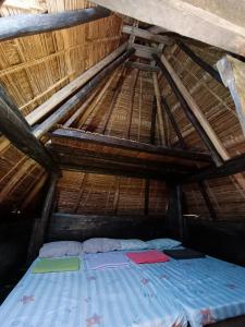 巴纳韦美景露台西望酒店的茅草屋顶间的一张床