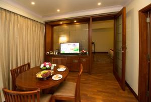 斋浦尔克拉里翁贝拉卡萨机场酒店的一间带桌子和电视的用餐室