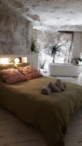 武夫赖La Trog'Laudy gîte 4 étoiles au coeur des vignes的一间卧室配有一张大床和两条毛巾
