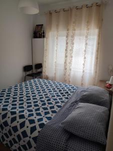 巴雷鲁CasaBarreiro的卧室配有蓝色和白色的床和窗帘