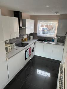 LemingtonLarge spacious 3 bedroom house Westerhope的厨房配有白色橱柜、水槽和洗碗机。