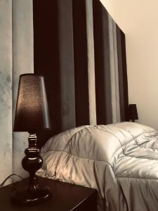 莫塔·圣塔纳斯塔西亚Motta Palace Apartments & Rooms的床头桌旁的灯
