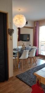 瓦尔弗雷加斯Au Centre de la station de ski de Valfréjus - appartement 4-6 personnes的一间带桌子和白色椅子的用餐室