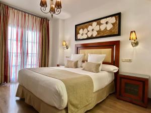 格拉纳达罗德里旅馆的一间卧室设有一张大床和一个大窗户