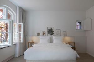 柏林Wilmina Hotel的白色卧室设有白色的床和2个窗户