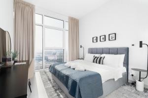 迪拜Ultimate Stay / 3 Beds / Gorgeous Frame and Park View / 250m from Metro / 1 Stop from World Trade Center的白色的卧室设有一张大床和一个窗户