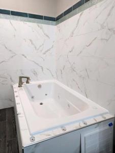 比洛克西Wingate by Wyndham Biloxi - Ocean Springs的浴室设有白色浴缸,拥有大理石墙壁。