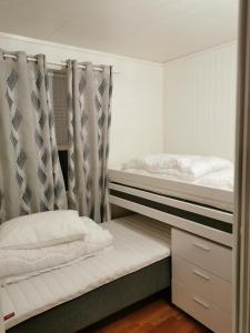 NyksundNyksundRom, Nyksund的一间卧室配有两张双层床和窗帘