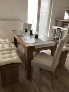 克拉尼Garden House的一张带白色椅子的木桌和一张木桌