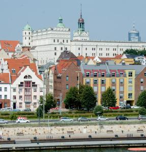 什切青Cocorico Bed and Breakfast OLD TOWN Szczecin Adults Only的城市,有河流,建筑和汽车