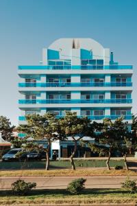 埃斯特角城Apart Hotel Punta Azul的一座高大的蓝色建筑,前面有树木