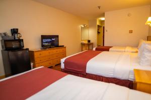怀特霍斯Canadas Best Value Inn- Riverview Hotel的酒店客房设有两张床和一台平面电视。