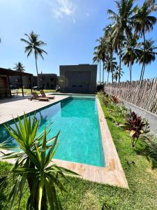 佩德拉斯港PATACHO VILLE - Rota Ecológica dos MILAGRES的一座楼前棕榈树游泳池