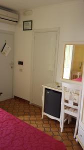 蓬扎Hotel Del Capitano的客房设有一张床、一张书桌和一面镜子