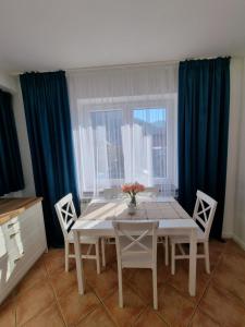 什切尔克Apartamenty Kolorowa的一间带桌椅和窗户的用餐室