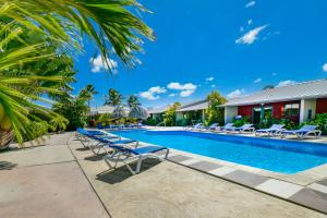 棕榈滩阿鲁巴蓝村公寓酒店的一个带躺椅的游泳池,一个度假村