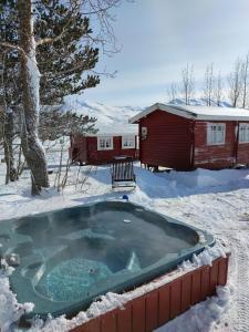 达尔维克达尔维克维加莫旅馆的小屋旁的雪地里设有热水浴池