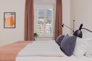 因斯布鲁克Marktbar Studios - Boutique Aparthotel的卧室配有白色的床和窗户