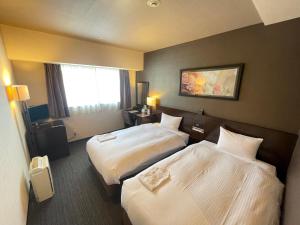 横滨新横滨拉古纳套房酒店的酒店客房设有两张床和窗户。