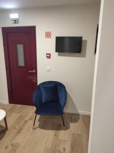 萨布盖鲁Casa dos Conchos 2的一把蓝色椅子坐在带门的房间