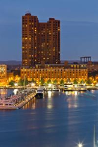 巴尔的摩The Royal Sonesta Harbor Court Baltimore的港口里船只在夜间停靠的城市