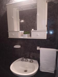 特尔马斯德里奥翁多Casa Termas的浴室配有盥洗盆、镜子和毛巾
