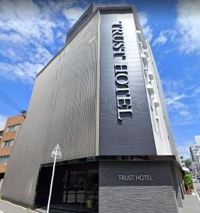 广岛Trust Hotel的上面有信托酒店标志的建筑