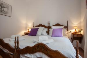 瓦伦西亚玛丽蒂姆公寓的一间卧室配有一张大床,提供紫色和白色枕头